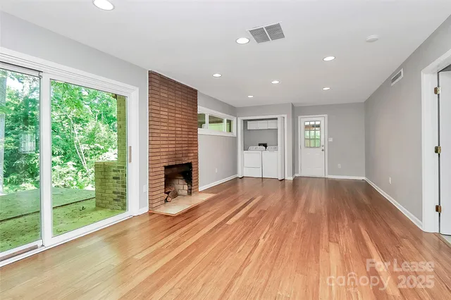 a view of empty room with wooden floor and fireplace