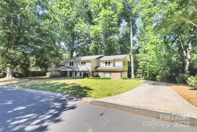 a front view of a house with a yard and trees