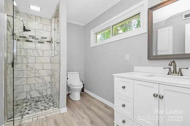a bathroom with a sink a toilet and shower
