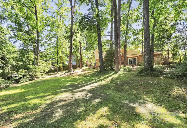 a backyard of a house with lots of green space and fountain