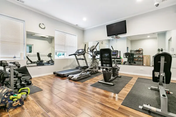a room with gym equipment and flat screen tv