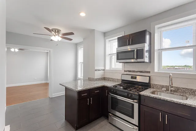 a kitchen with stainless steel appliances granite countertop a sink and a stove