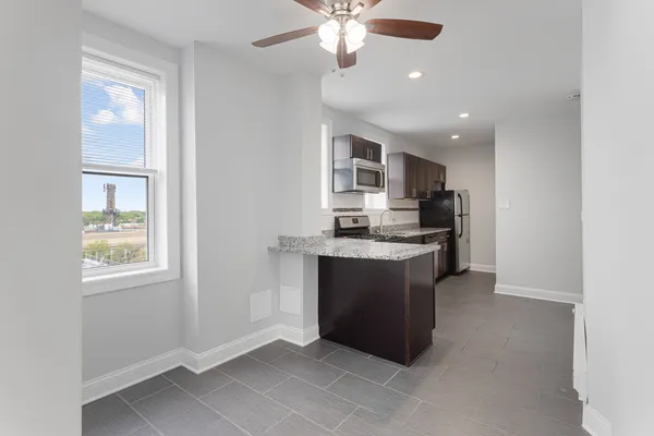 a kitchen with kitchen island granite countertop appliances cabinets and a sink