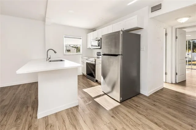 a kitchen with stainless steel appliances a refrigerator sink and microwave