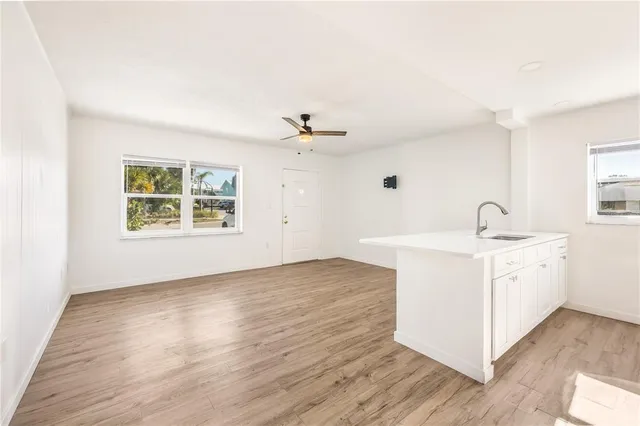 a view of a kitchen with sink and wooden floor