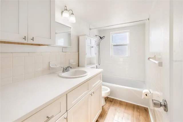 a bathroom with a sink double vanity granite tub shower and a mirror