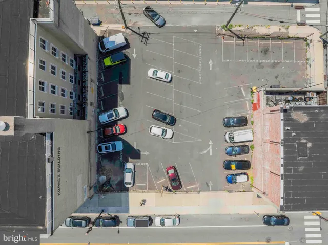 a view of a street with cars parked in front of a building
