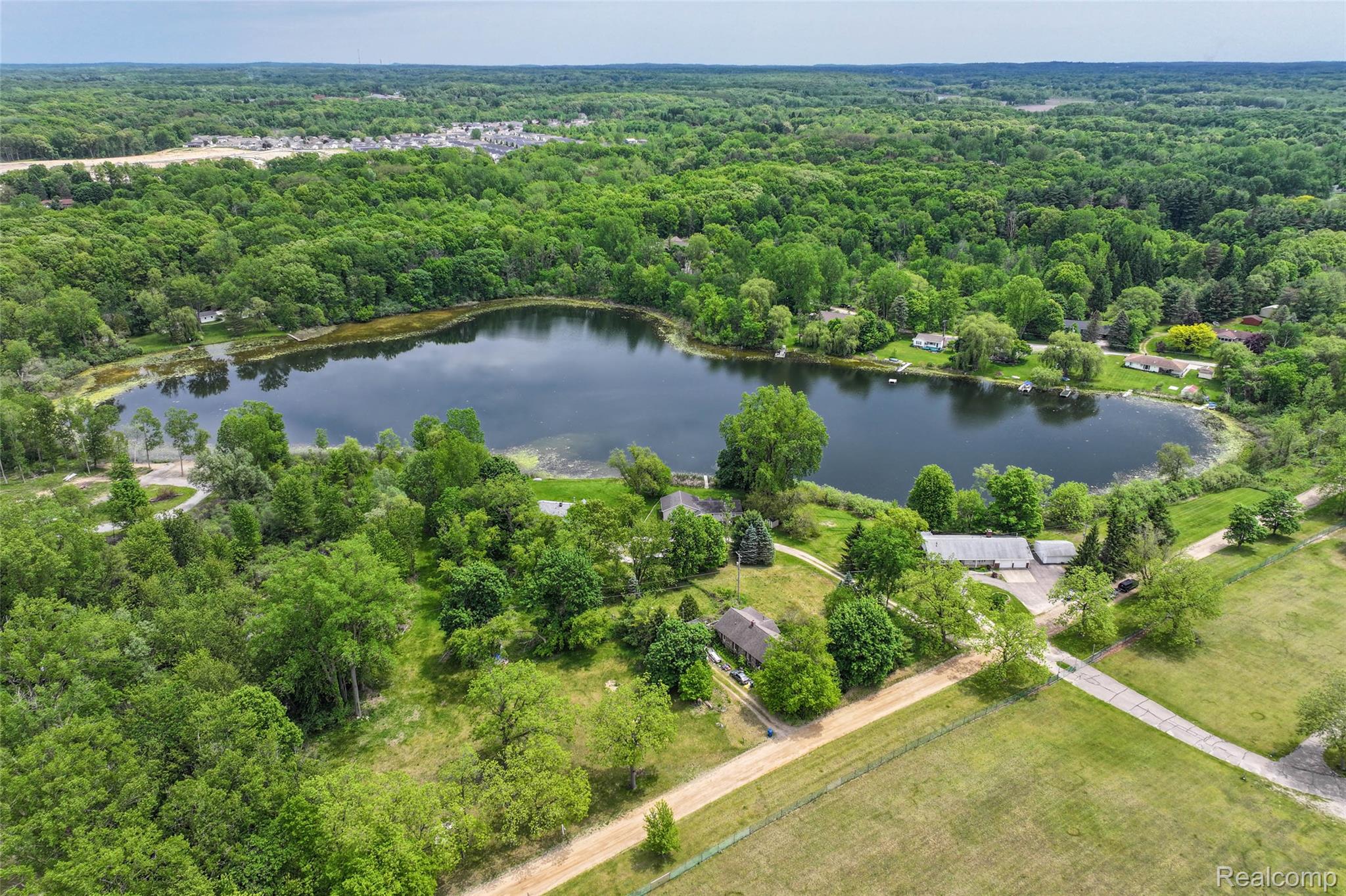 422 East Road Holly, MI 48442 - Photo 43 of 51 Aerial overview of a freshwater lake surrounded by verdant trees and residential properties