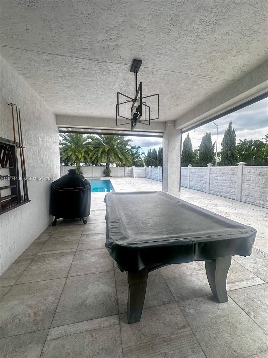 14680 Southwest 17th Street Miami, FL 33175 - Photo 20 of 68 a view of a patio with table and chairs potted plants with floor to ceiling window
