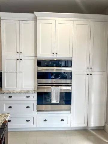 a bedroom with a bed couch and a chandelier