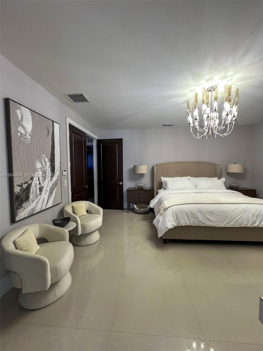 14680 Southwest 17th Street Miami, FL 33175 - Photo 45 of 68 a spacious bedroom with a bed and a chandelier
