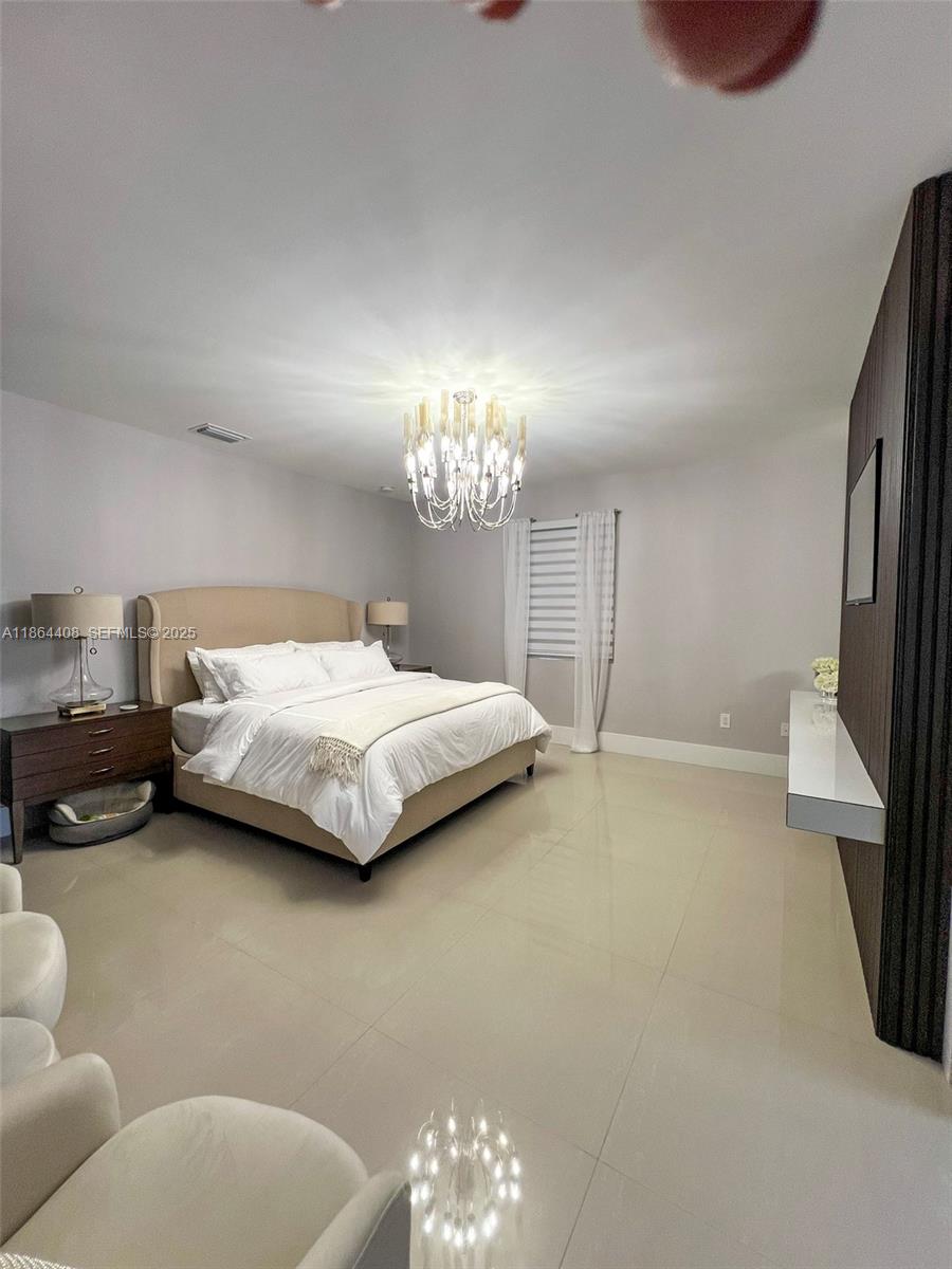 14680 Southwest 17th Street Miami, FL 33175 - Photo 46 of 68 a bedroom with a bed window and a chandelier