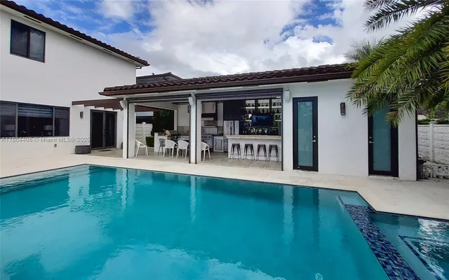 a view of backyard with swimming pool and seating space