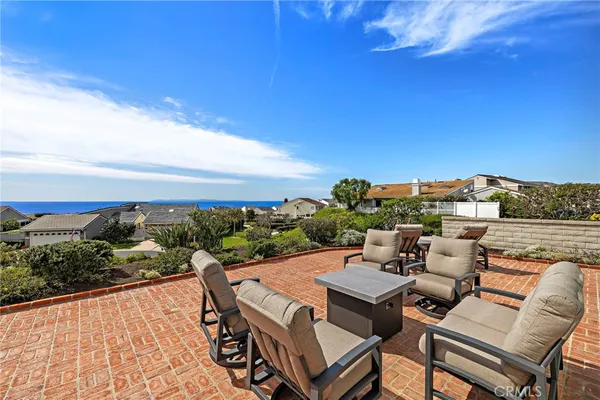 a view of a terrace with furniture and a garden
