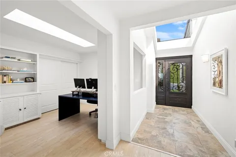 a view of a workspace with wooden floor and kitchen space