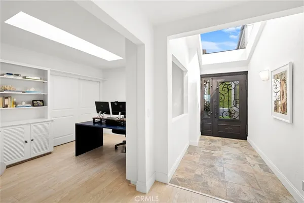 a view of a workspace with wooden floor and kitchen space