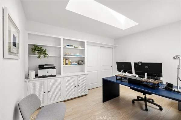 a view of a workspace with furniture and a window