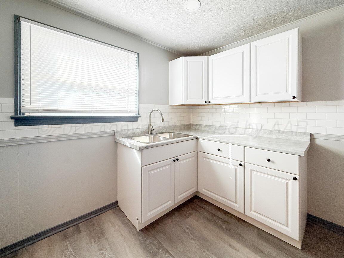 4224 South Polk Street Amarillo, TX 79110 - Photo 45 of 55 a kitchen with white cabinets window and sink