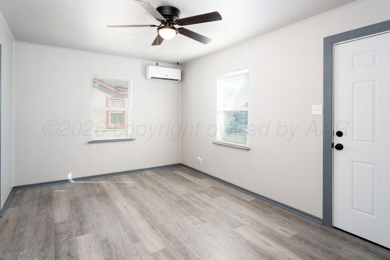 4224 South Polk Street Amarillo, TX 79110 - Photo 7 of 55 wooden floor in an empty room with a window