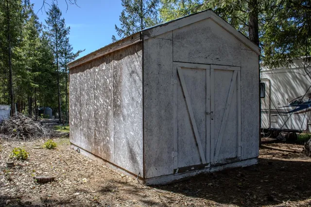 a view of garden with plants and wooden fence