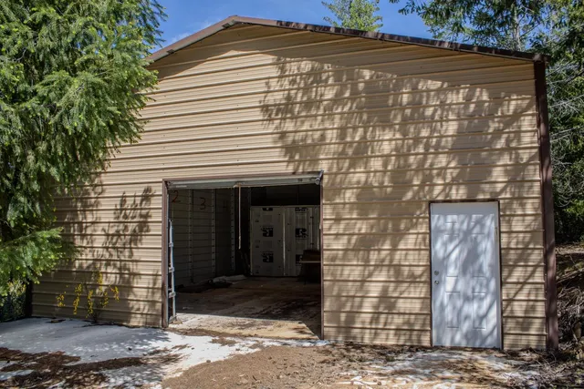 an aerial view of residential house with outdoor space and trees all around