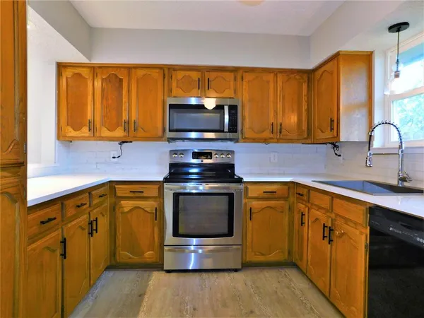 a kitchen with stainless steel appliances a stove a sink and a microwave