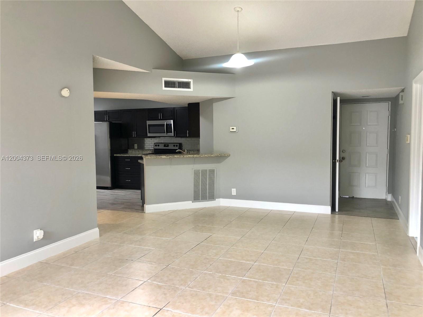 8761 Wiles Road, Unit 306 Coral Springs, FL 33067 - Photo 7 of 26 a view of a kitchen with a sink and a refrigerator