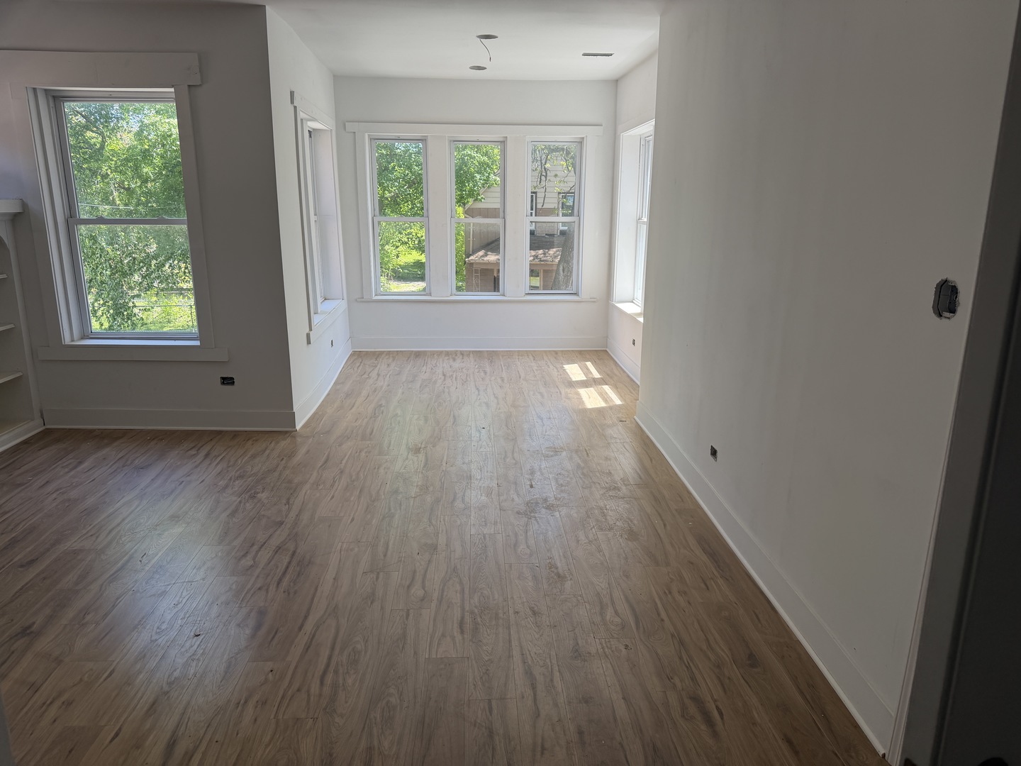 6716 South May Street Chicago, IL 60621 - Photo 2 of 9 a view of an empty room with wooden floor and a window