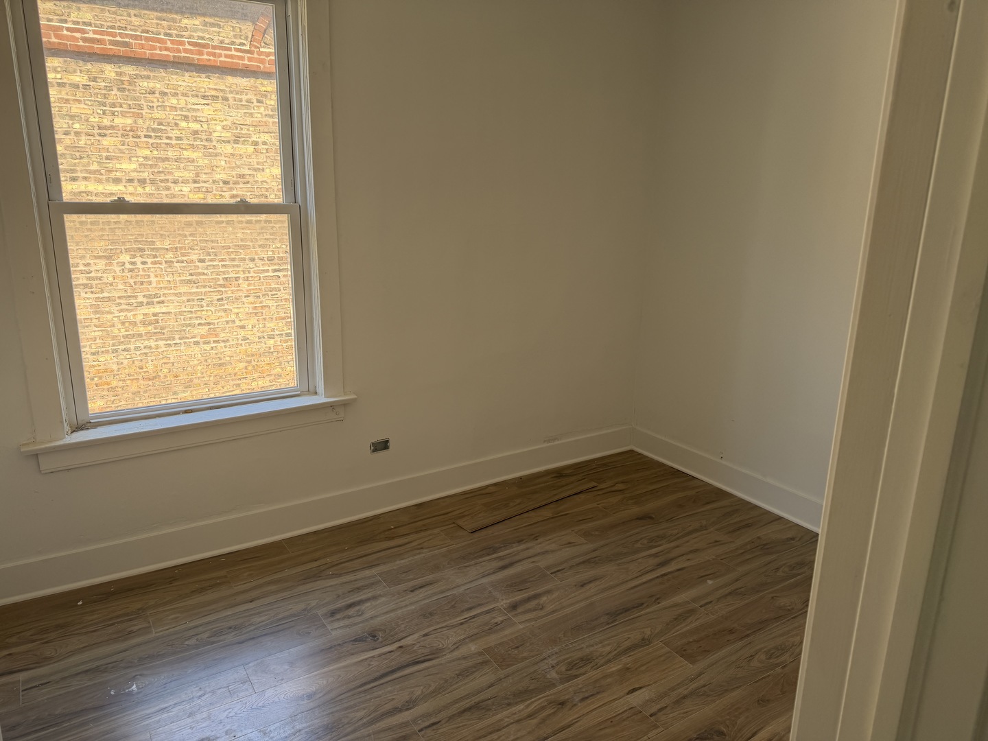 6716 South May Street Chicago, IL 60621 - Photo 7 of 9 a view of an empty room with wooden floor and a window