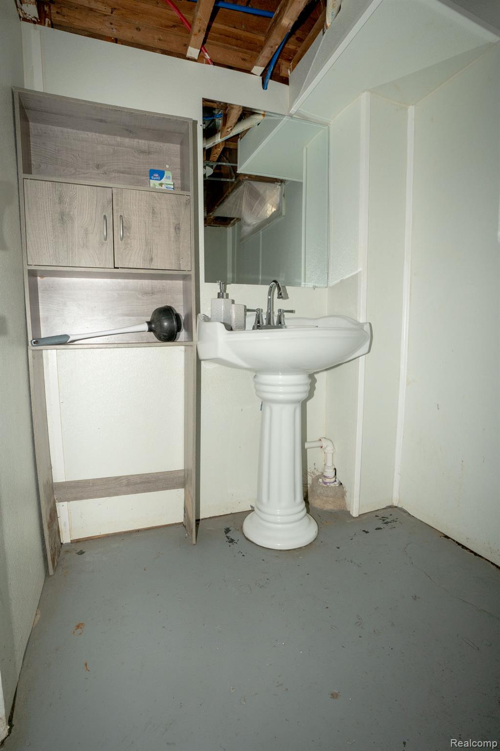 16821 East Eight Mile Road Eastpointe, MI 48021 - Photo 10 of 31 Pedestal sink with chrome fixtures and wall-mounted mirror