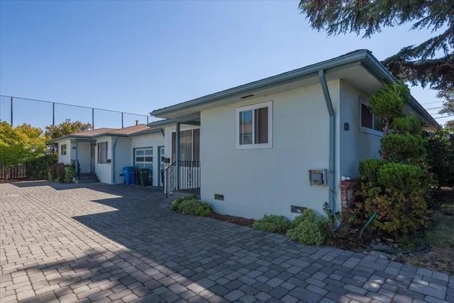 a front view of house with yard and trees around