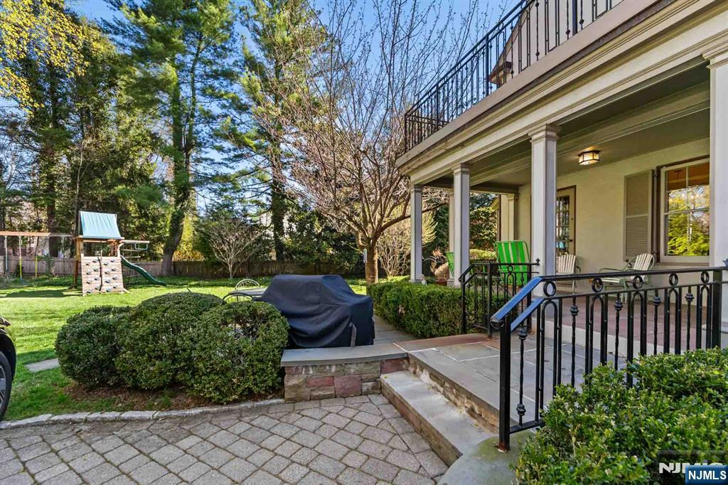 116 Lydecker Street Englewood, NJ 07631 - Photo 45 of 46 a view of a house with brick walls plants and large tree
