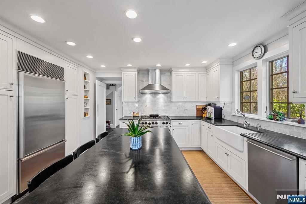 116 Lydecker Street Englewood, NJ 07631 - Photo 10 of 46 a large kitchen with stainless steel appliances lots of counter space and wooden floor