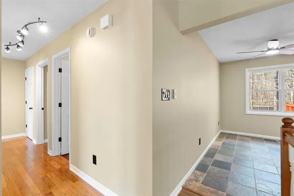 a view of an empty room with window and a ceiling fan