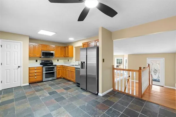 a kitchen with stainless steel appliances granite countertop a refrigerator and a stove top oven