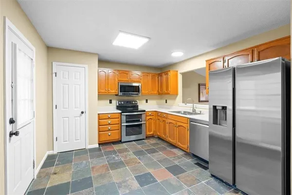a kitchen with granite countertop stainless steel appliances a stove sink microwave and cabinets