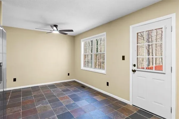 a view of an empty room with window and wooden floor