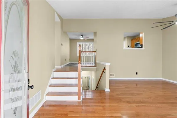 a view of a livingroom with wooden floor and a ceiling fan