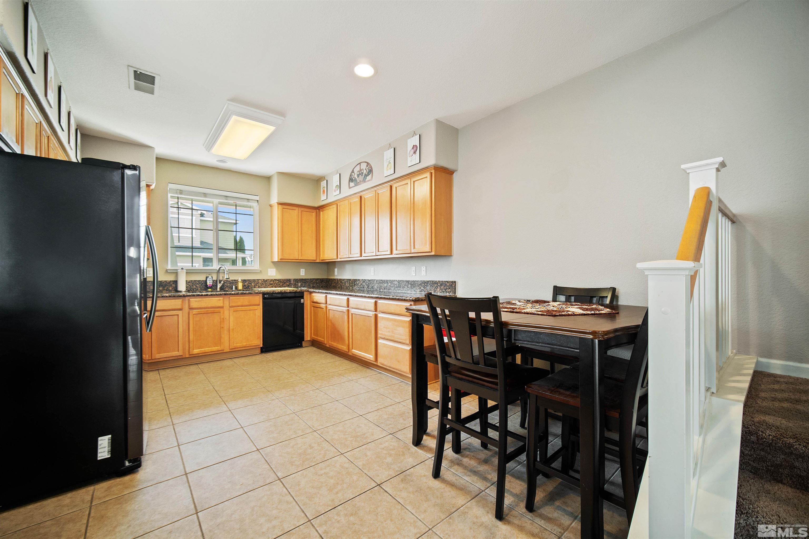 2110 Hellaby Lane Reno, NV 89502 - Photo 8 of 29 a kitchen with granite countertop a refrigerator and wooden cabinets