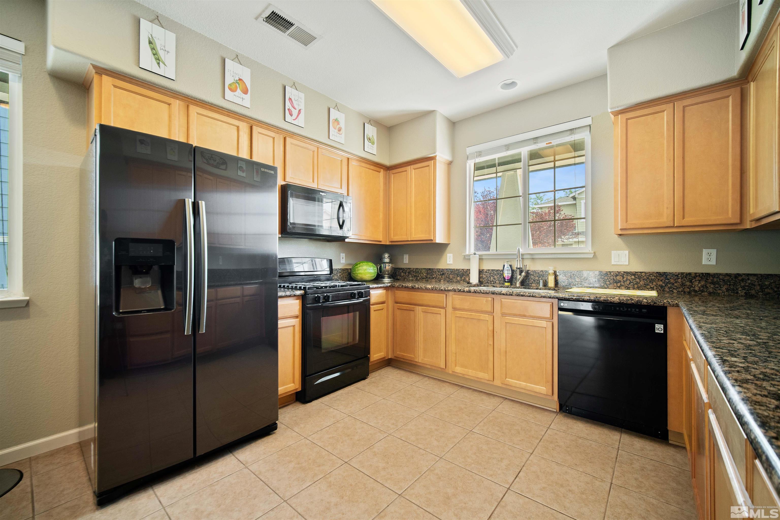 2110 Hellaby Lane Reno, NV 89502 - Photo 9 of 29 a kitchen with granite countertop a refrigerator and steel cabinets