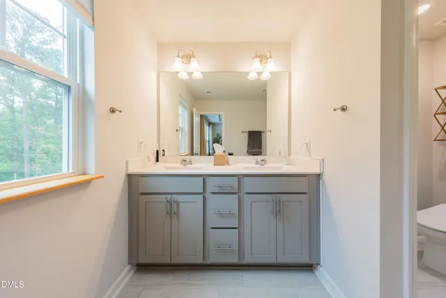 a bathroom with a double vanity sink and a mirror