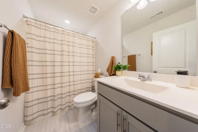 a bathroom with a sink mirror and toilet
