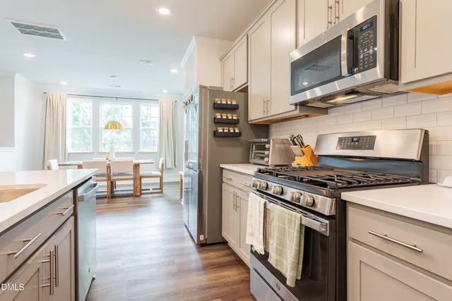 a kitchen with stainless steel appliances a stove sink microwave and cabinets