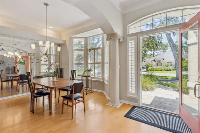 a dining room with furniture a chandelier and wooden floor