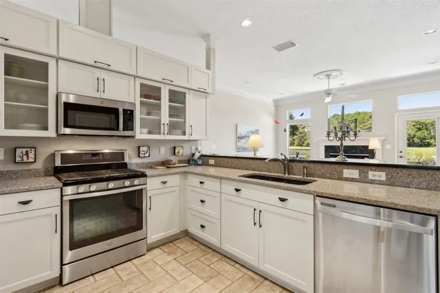 a kitchen with stainless steel appliances granite countertop a stove a sink and a microwave