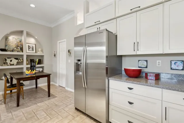 a kitchen with stainless steel appliances granite countertop a refrigerator and a cabinets