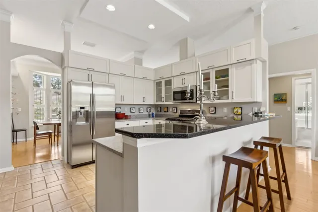 a kitchen with stainless steel appliances granite countertop a refrigerator and a stove top oven