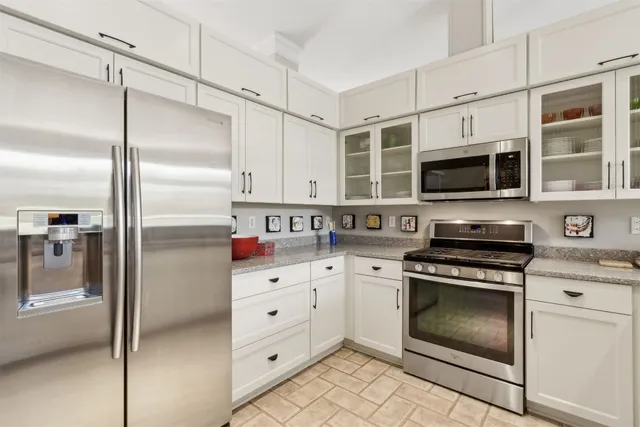 a kitchen with cabinets stainless steel appliances and a counter space