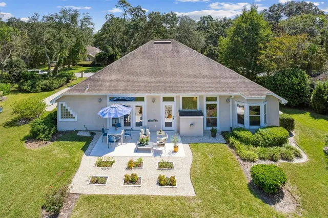 a view of house with backyard and outdoor seating