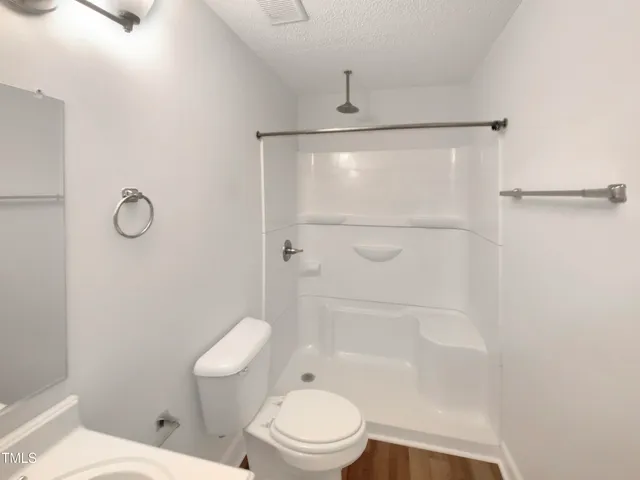 a white toilet sitting next to a bath tub